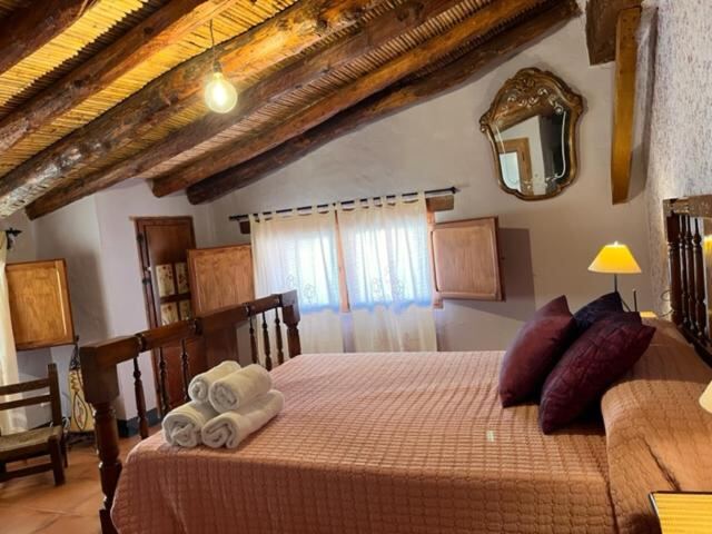 Attic bedroom with wooden beams and antique mirror