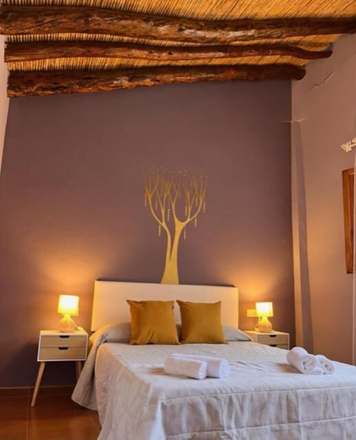 Bedroom with beamed ceiling at Casa rural La Boticaria